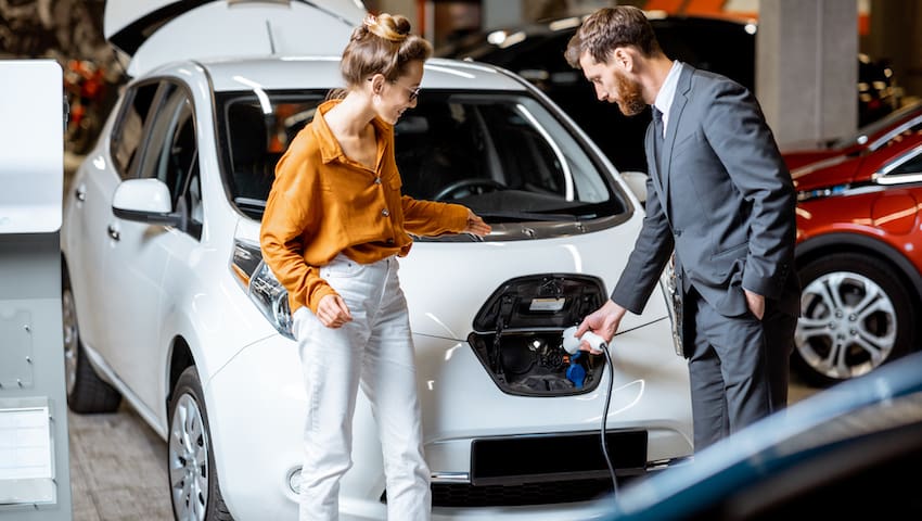 woman buying electric car showroom